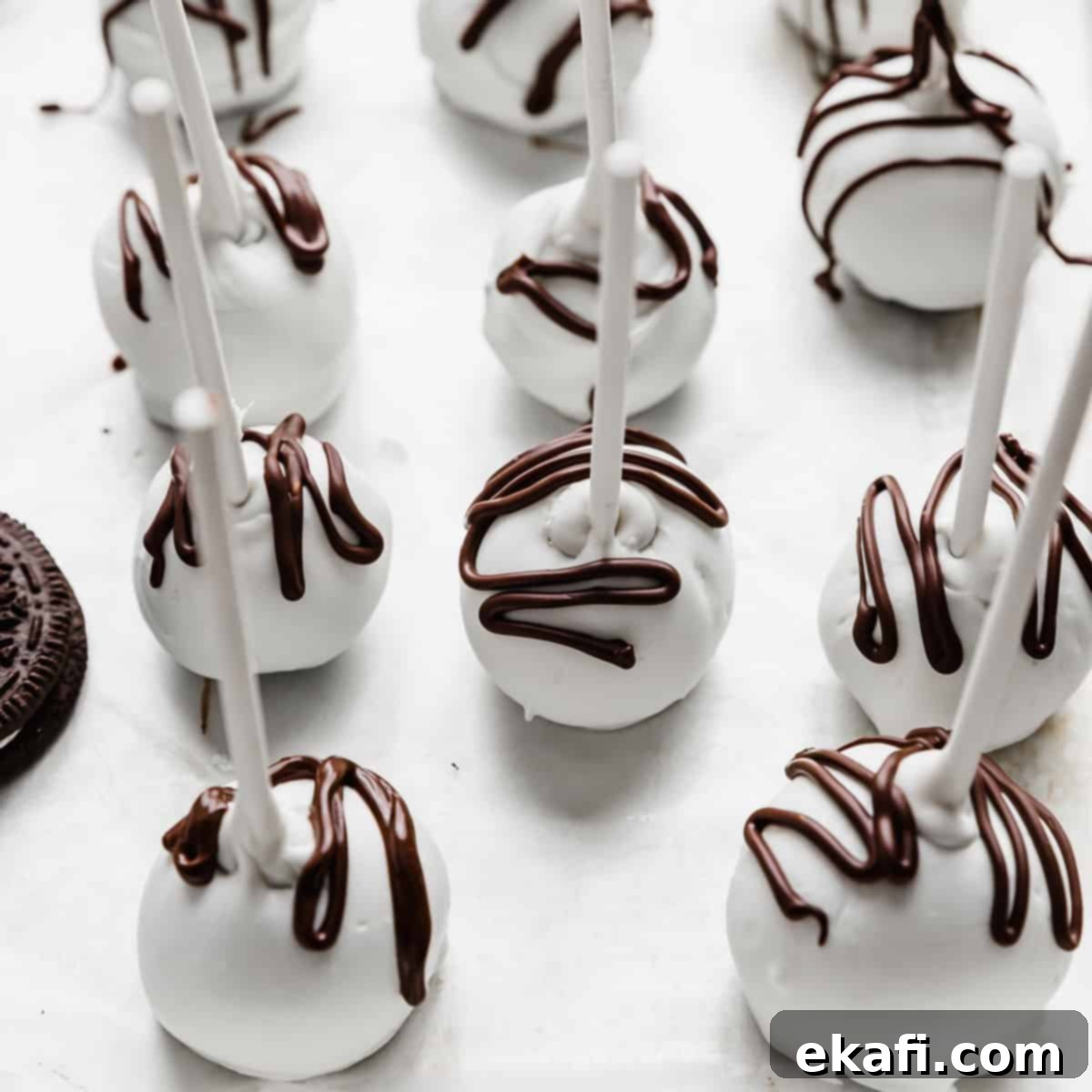 Μπουκιές Κέικ Όρεο 8 Λευκά σοκολατένια Oreo Pops με καφέ σοκολάτα περιχυμένη από πάνω.