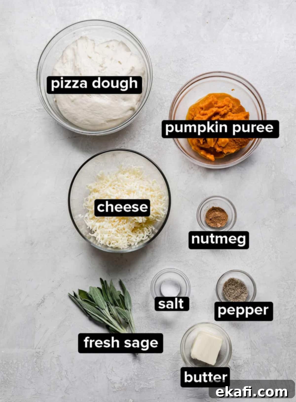 Harvest Moon Pizza 3 A collection of Pumpkin Pizza ingredients including pumpkin puree, spices, sage, and shredded cheese, neatly arranged in glass bowls on a gray background.