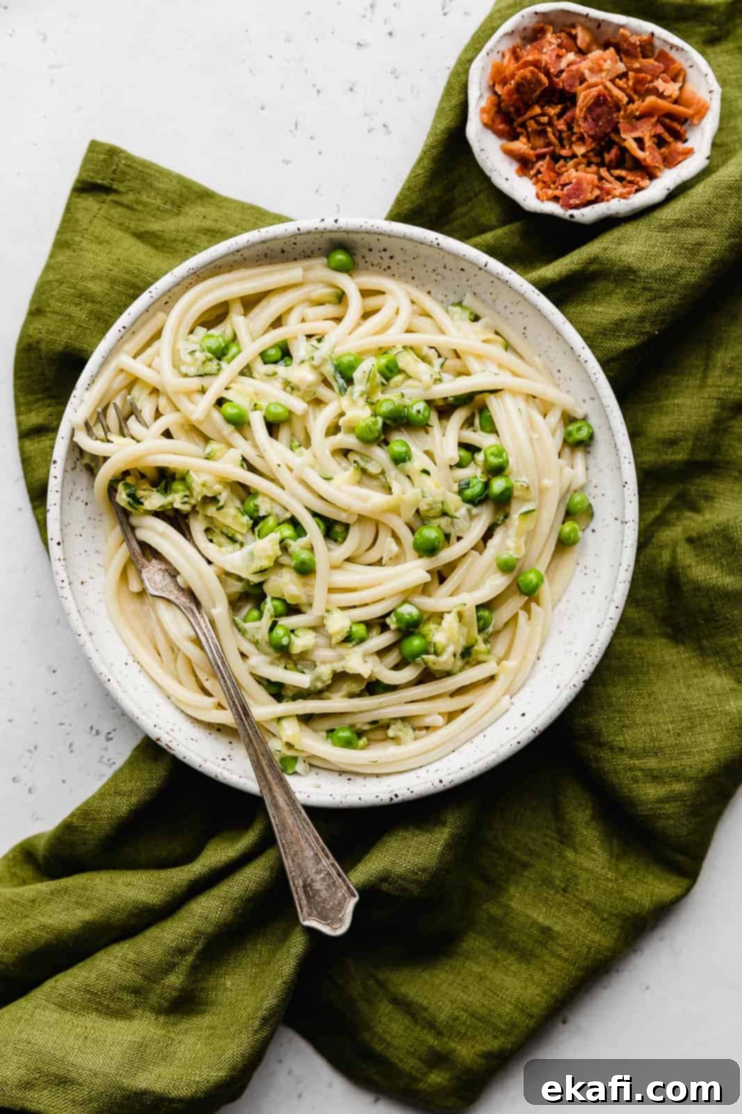Summer Zucchini Delight 2 A white plate with Pasta with Zucchini Sauce and green peas.