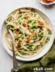 Summer Zucchini Delight 14 Pasta with Zucchini Sauce topped with chopped bacon on a white plate.