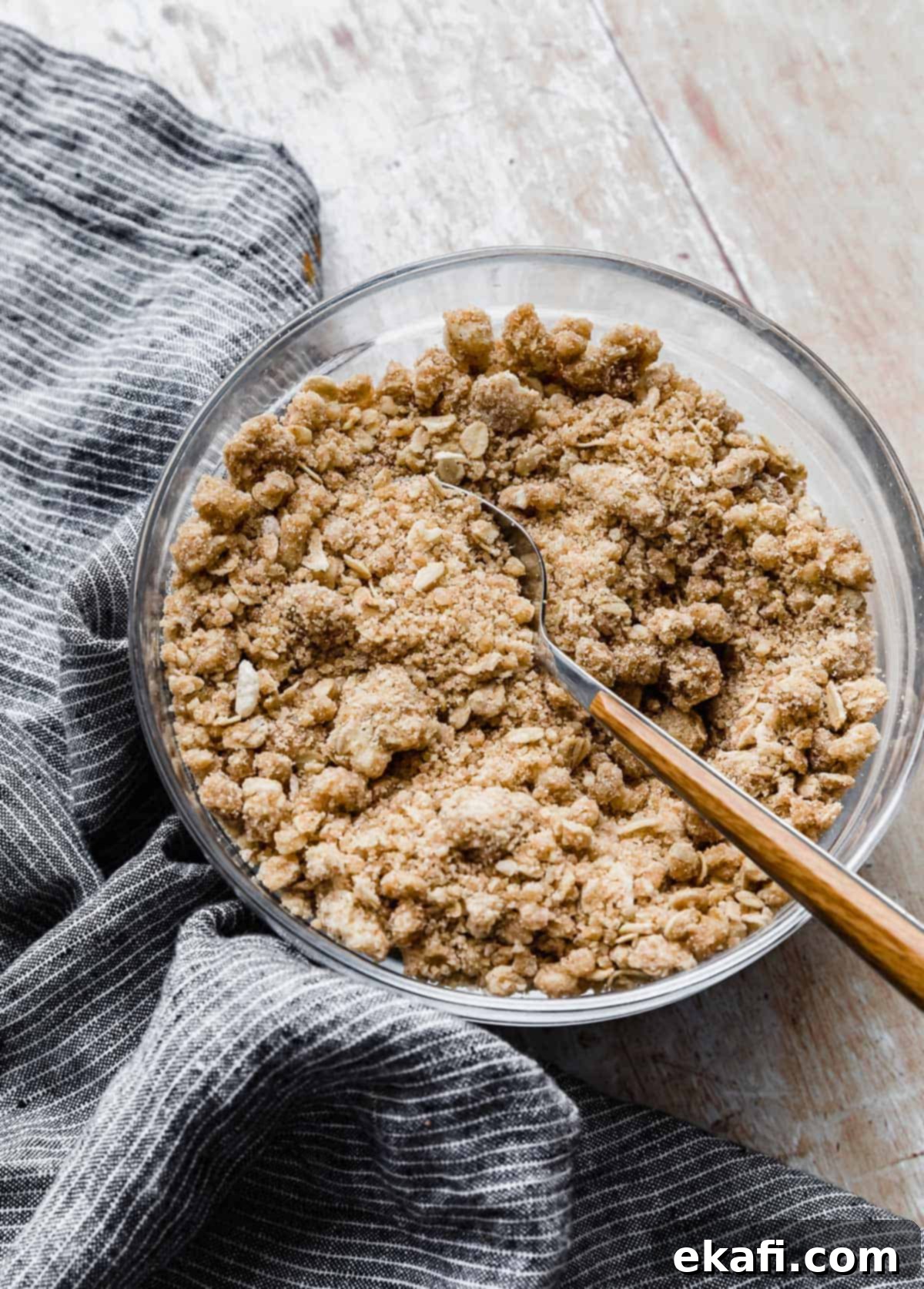 Crumbly Delight 2 A Streusel Topping in a glass bowl on a light wooden background.