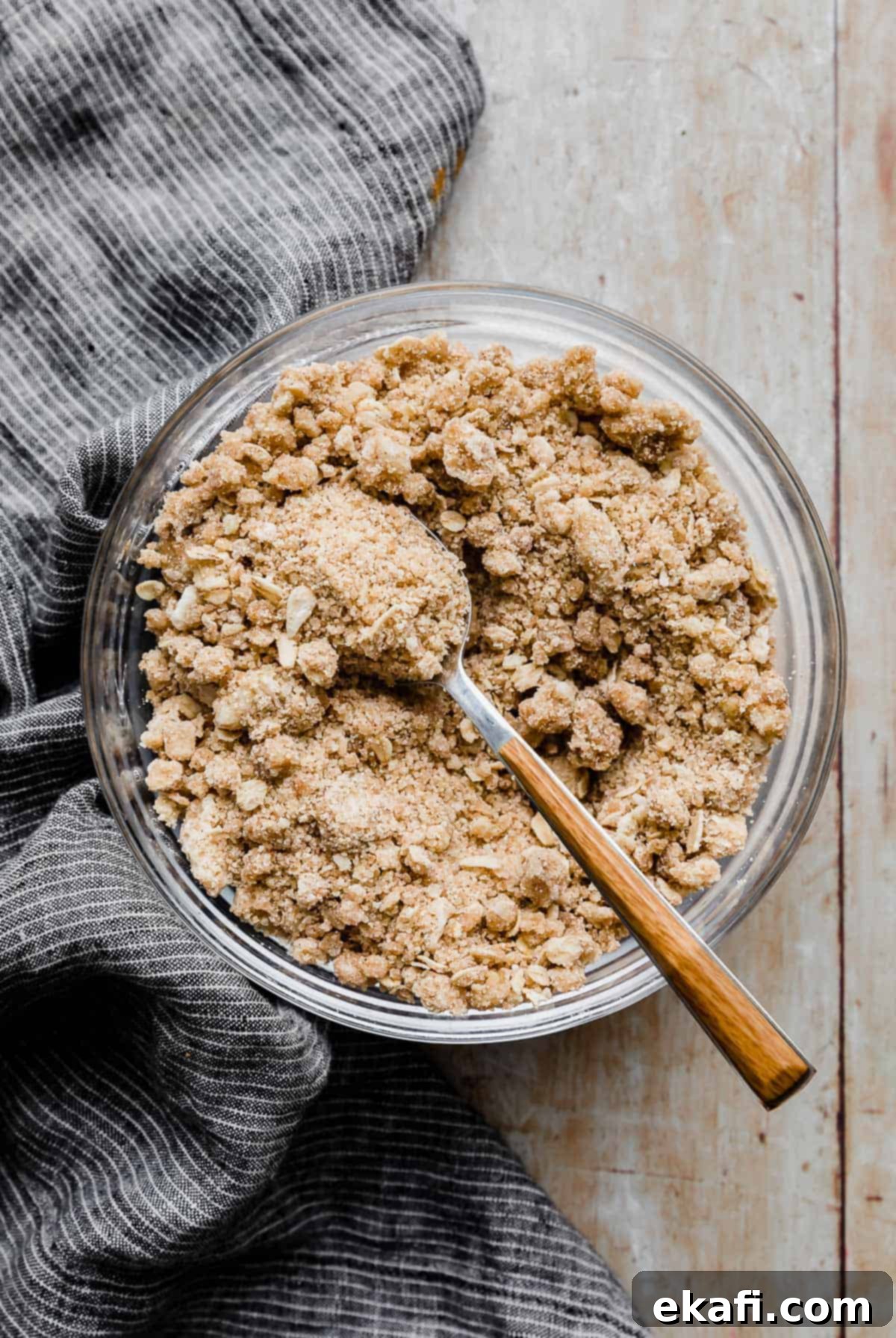 Crumbly Delight 8 A Streusel Topping Recipe in a glass bowl with a spoon scooping some out.