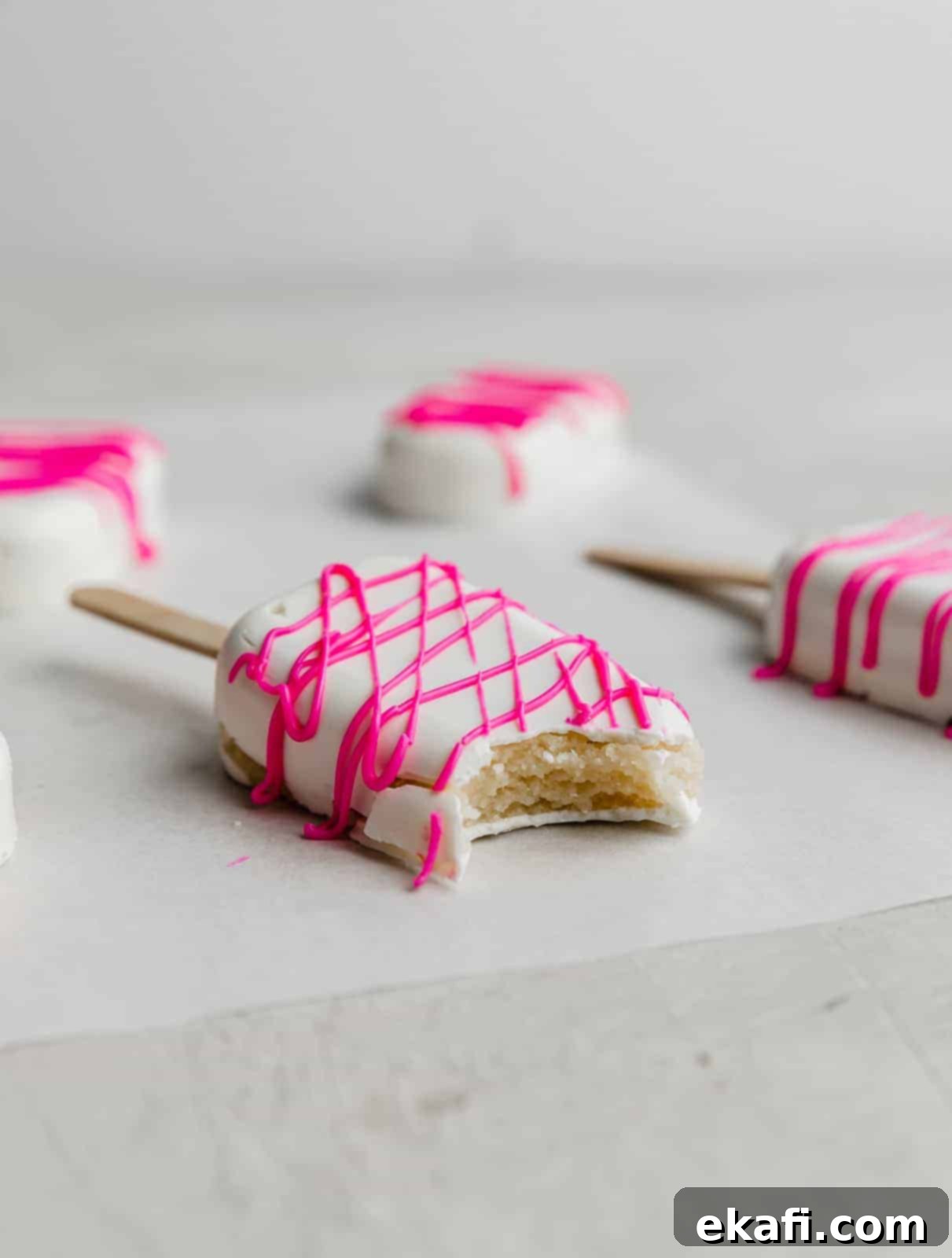 Κεκάκια Παγωτό 11 Ένα λευκό Cakesicle με ένα δάγκωμα, σε λευκό φόντο.