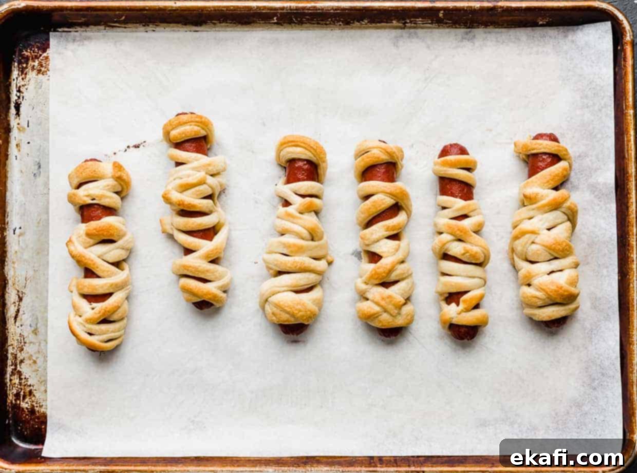 Mummy Hot Dogs 7 Baked Mummy Hot Dogs on a baking sheet.