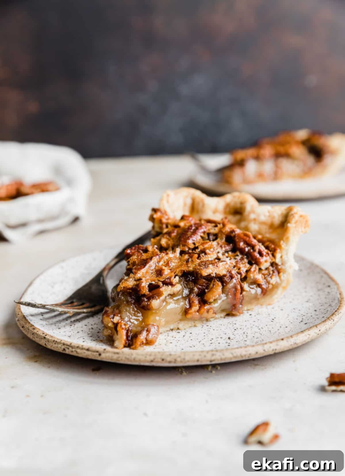 Sweet Southern Comfort: The Perfect Pecan Pie 9 A perfectly baked slice of Southern Pecan Pie, featuring a crisp crust, gooey filling, and a generous layer of caramelized pecans, presented on a white plate with a fork.