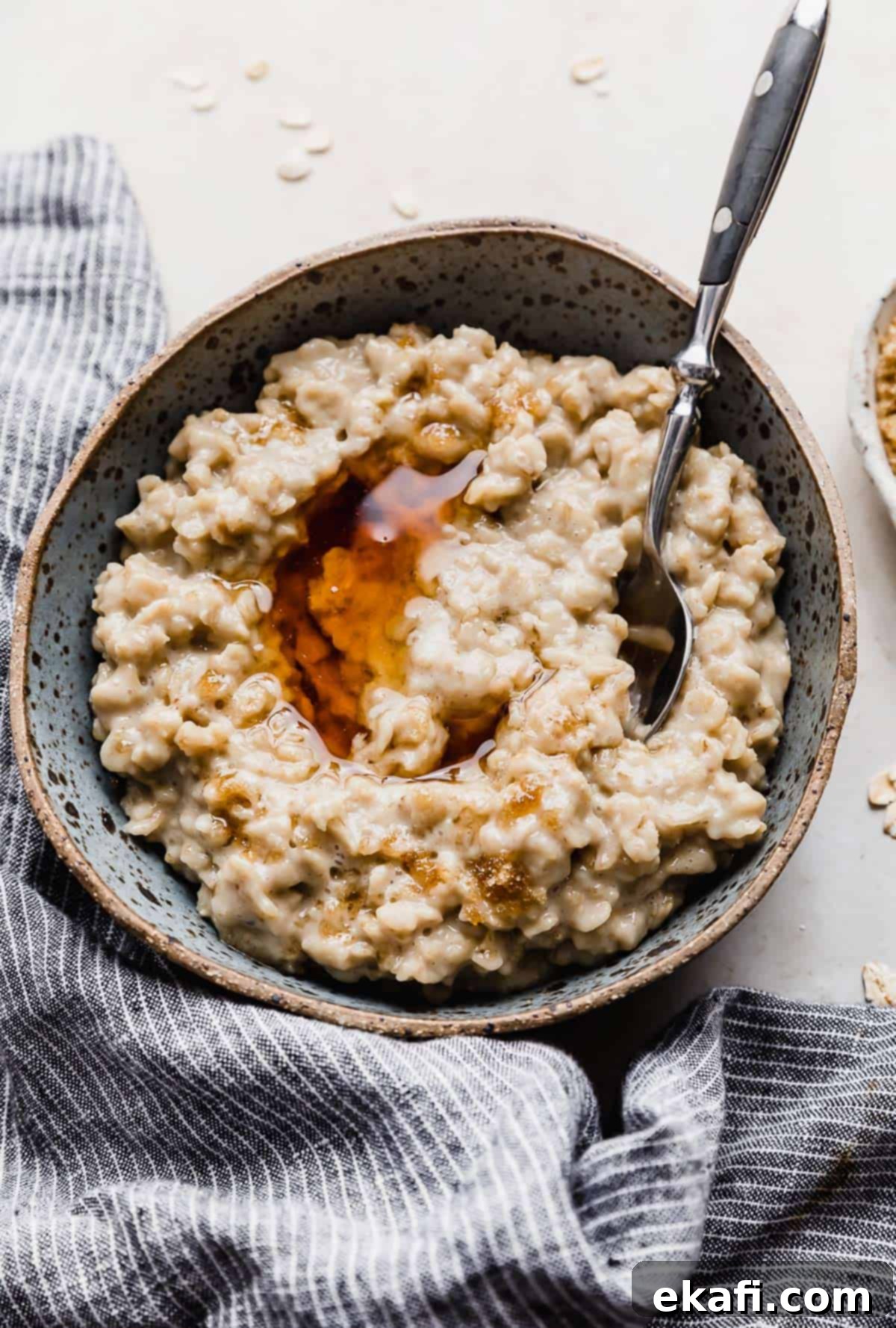 Golden Maple Brown Sugar Oats 2 Maple and Brown Sugar Oatmeal in a blue bowl with a drizzle of maple syrup over the oatmeal.