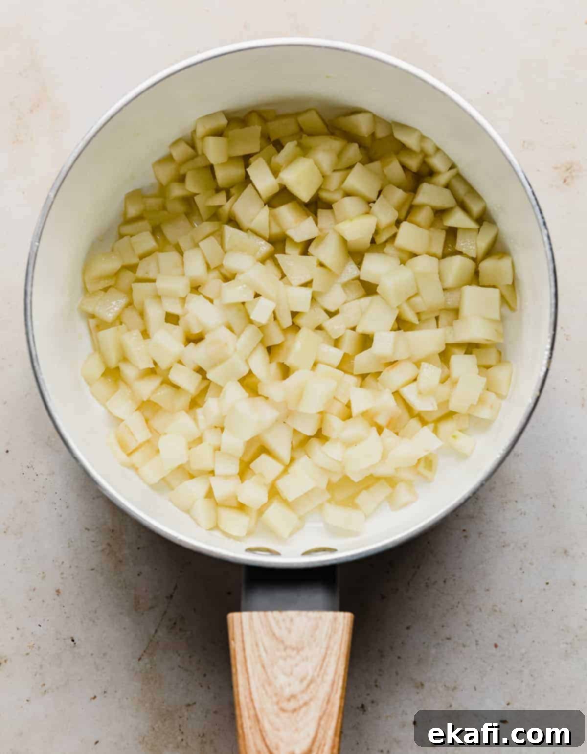 Flaky Apple Turnovers 5 Softened diced apples in a white saucepan.