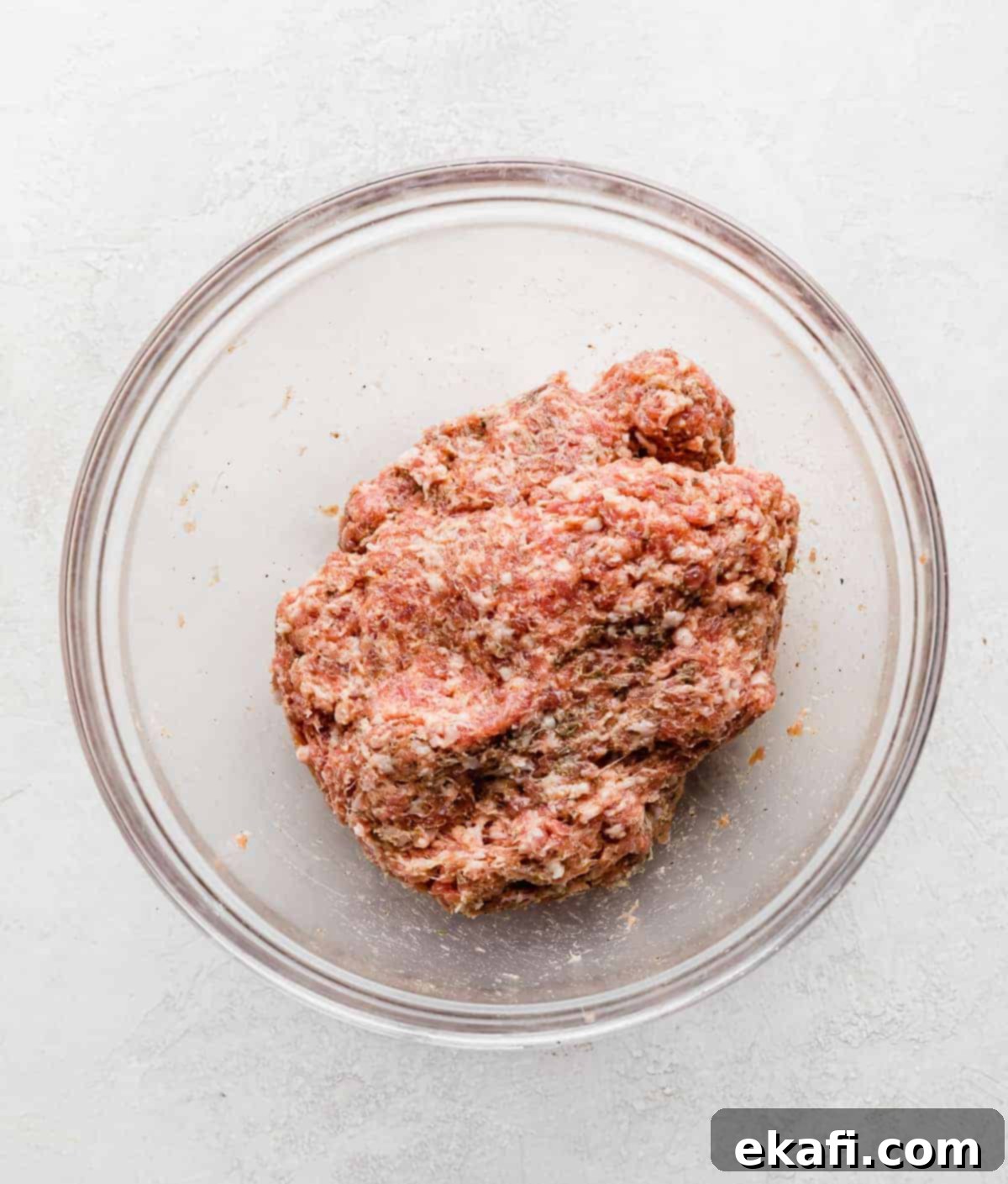 From Scratch Sausage and Egg Breakfast Sandwich 5 A close-up of the seasoned ground pork mixture in a glass bowl, showcasing the uniform blend of meat and spices before being formed into patties.