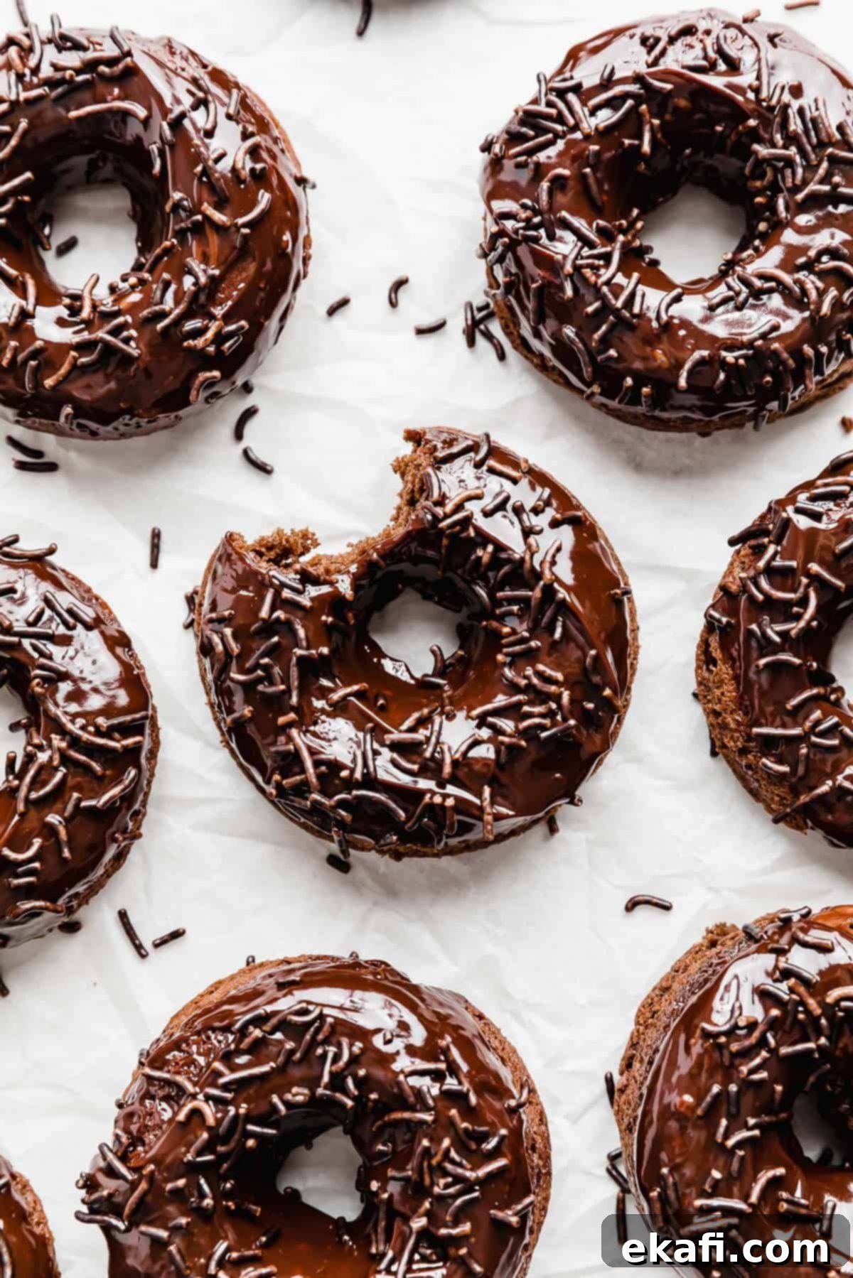 Ultimate Chocolate Donuts 2 Irresistible Baked Chocolate Doughnuts topped generously with chocolate sprinkles, presented beautifully on a clean white background. Perfect for a sweet treat.