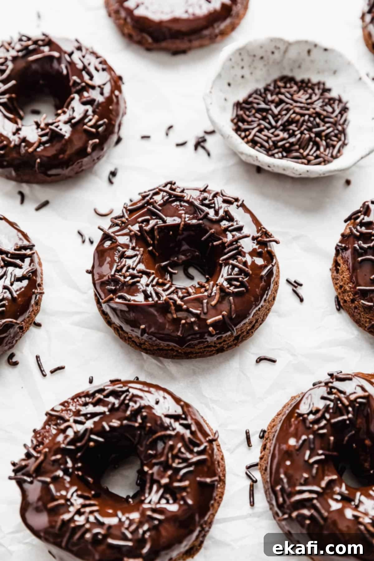 Ultimate Chocolate Donuts 13 Baked Chocolate Doughnuts beautifully topped with a glossy chocolate glaze and colorful chocolate sprinkles, ready to be enjoyed.