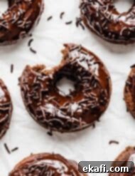 Ultimate Chocolate Donuts 15 A delightful Chocolate Doughnut on a pristine white background, a tempting bite taken out, revealing its soft, moist interior. A true treat!