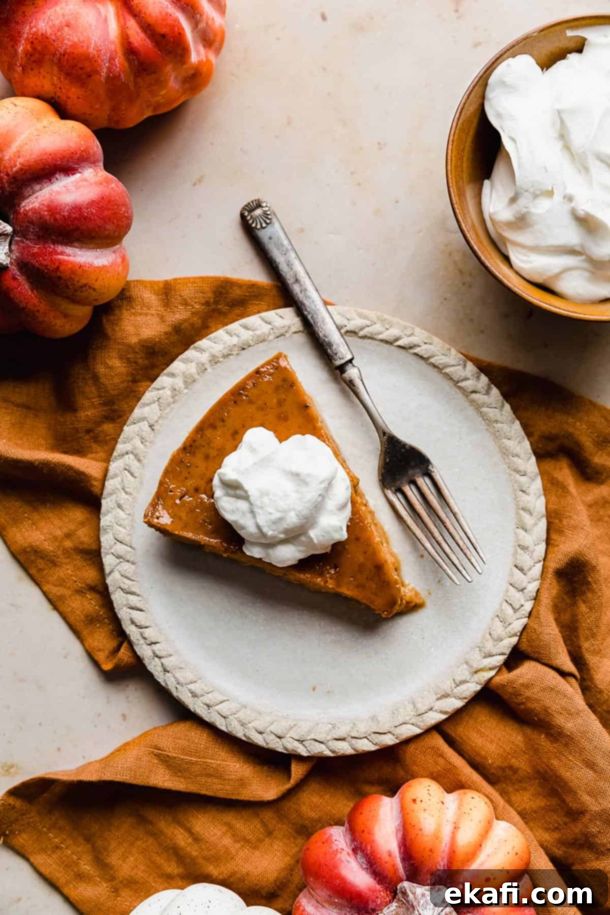 Pure Pumpkin Custard 2 A beautifully presented slice of Crustless Pumpkin Pie topped with a generous dollop of fluffy whipped cream, inviting you to take a bite.