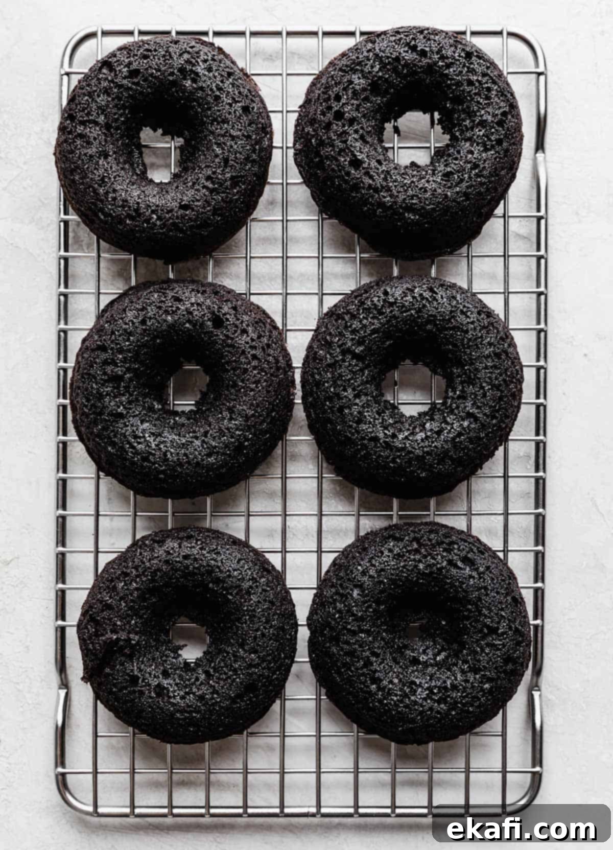 Cookies and Cream Donuts 11 Six baked Oreo Donuts on a wire cooling rack.