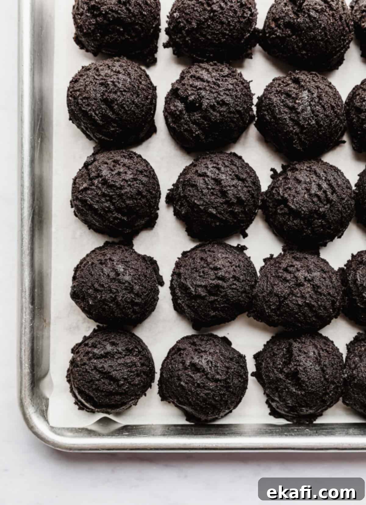 Craft Your Own Chocolate Cream Sandwiches 8 Oreo cookie dough balls on a baking sheet.