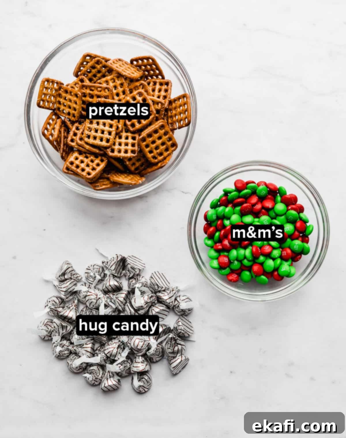 Christmas Pretzel Hugs 3 Christmas Pretzel Hugs ingredients laid out on a marble background.