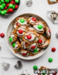 Christmas Pretzel Hugs 7 Red and green candy topped Christmas Pretzel Hugs on a white background.