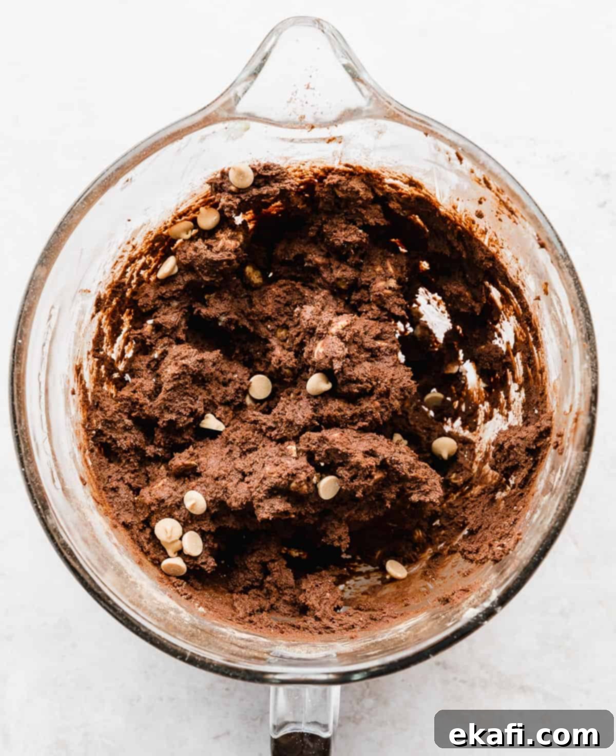 Decadent Peanut Butter Chocolate Chip Cookies 4 Close-up of rich, dark Chocolate Peanut Butter Chip Cookie dough swirled with creamy peanut butter chips in a glass mixing bowl.