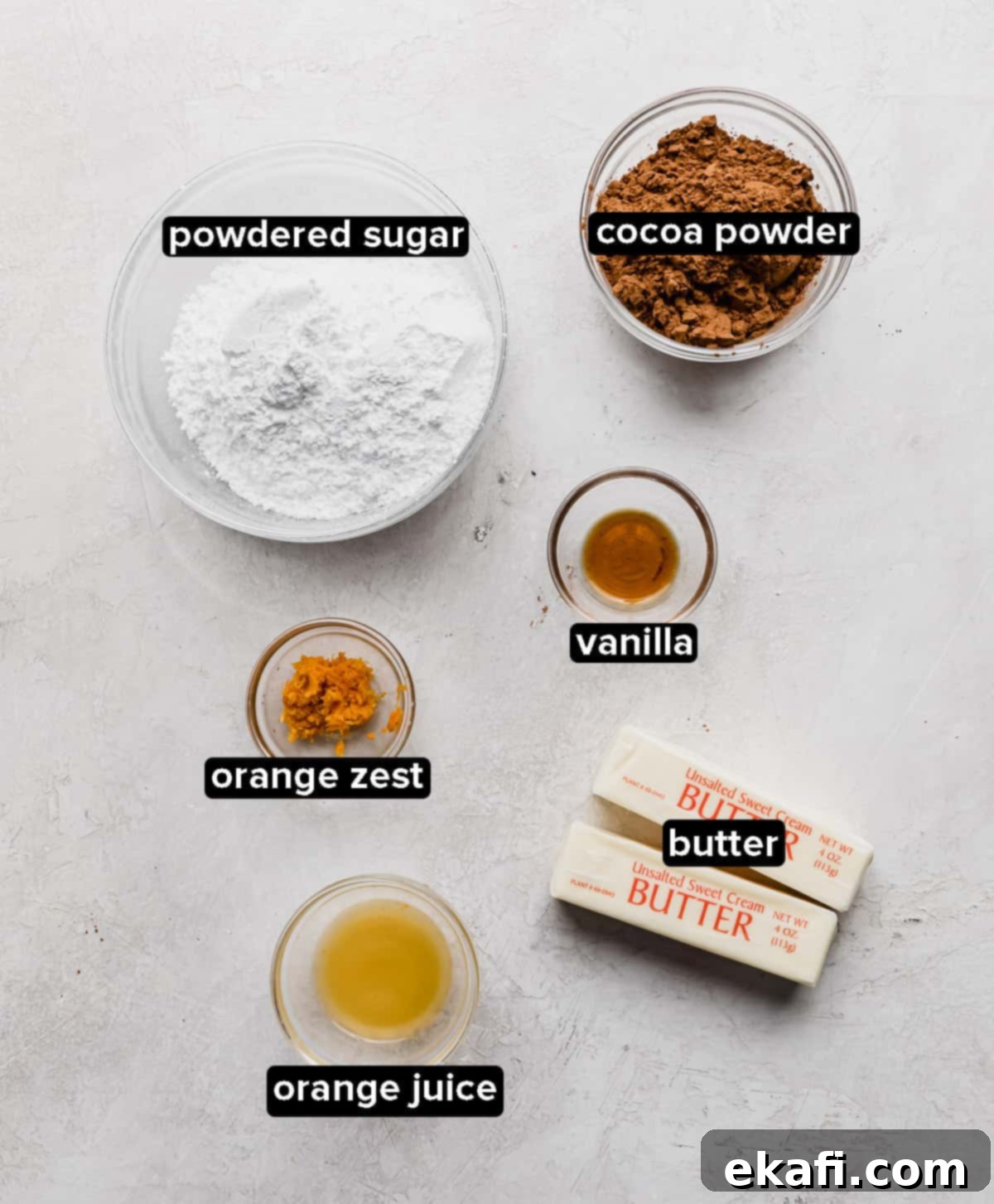 Zesty Chocolate Orange Delights 4 Chocolate Orange Frosting ingredients in glass bowls: butter, orange juice and zest, vanilla, cocoa powder, and powdered sugar.