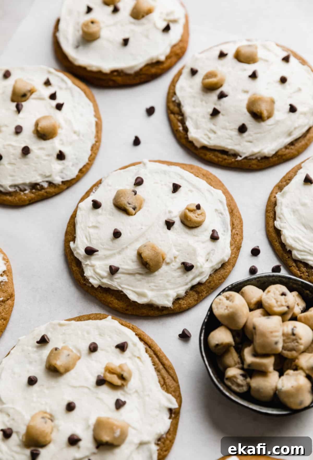 Κραμπλ Μπισκότα Ζύμης Μπισκότου 11 Crumbl Cookie Dough Cookies με λευκό γλάσο, μικροσκοπικά κομματάκια σοκολάτας και βρώσιμα κομμάτια ζύμης μπισκότων.