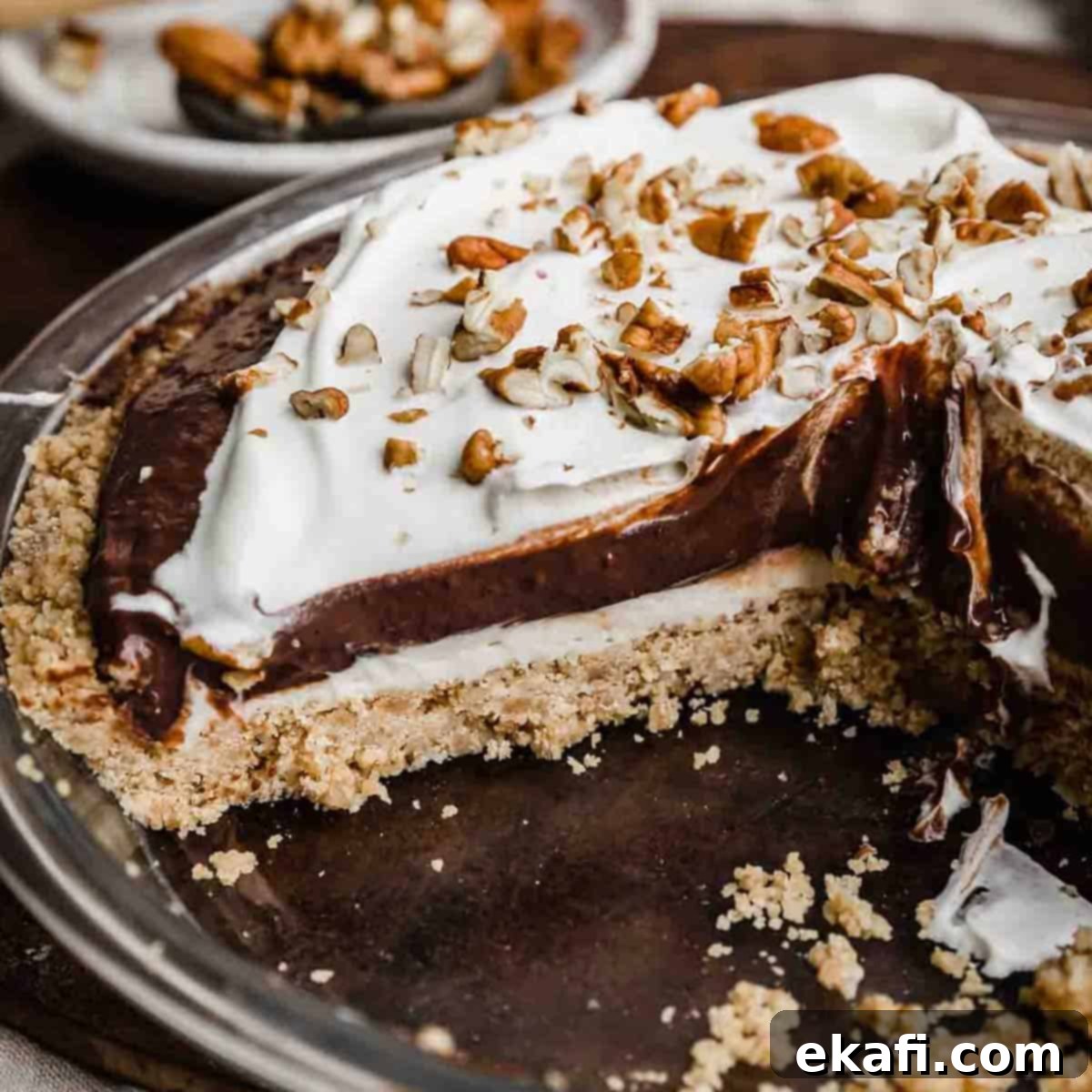 Οι Απόλυτες Πίτες Ευχαριστιών 15 Μια Arkansas Possum pie κομμένη σε φέτες, δείχνοντας την κρούστα σόρτμπρεντ πεκάν, τη στρώση τυριού κρέμας, τη στρώση σοκολατένιας πουτίγκας και τις στρώσεις σαντιγί.