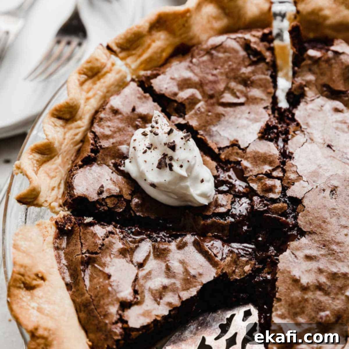 Οι Απόλυτες Πίτες Ευχαριστιών 22 Μια τάρτα brownie κομμένη σε πολλές μερίδες, με μια φέτα από πάνω με λευκή σαντιγί και ξύσματα σοκολάτας.