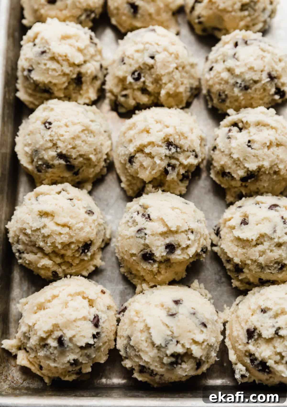 Crumbl's Mint Chip Ice Cream Cookie Delight 6 Mini chocolate chip studded sugar cookie dough balls lined up next to one another.