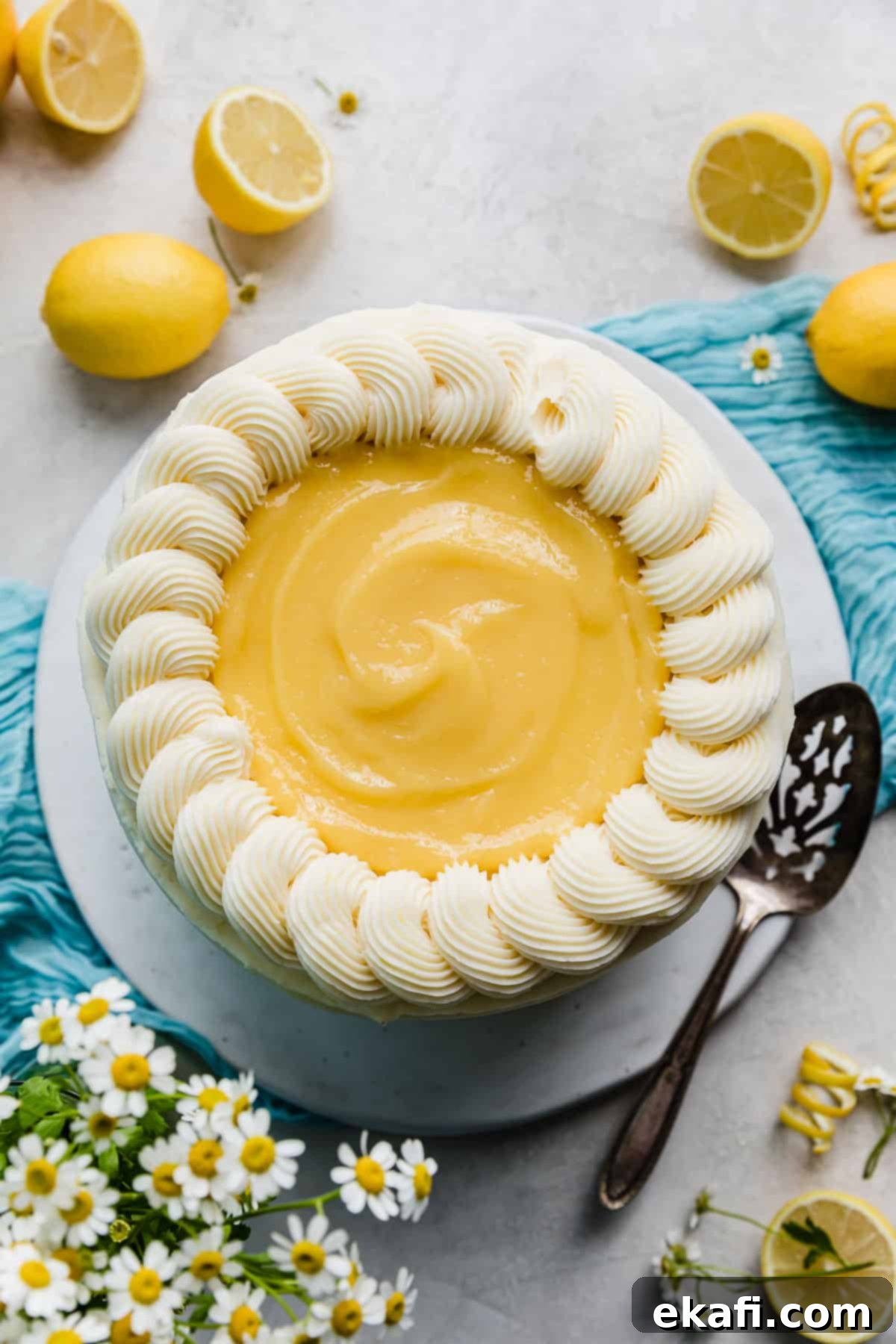Zesty Lemon Bar Cake 3 Overhead photo of a Lemon Bar Cake that's topped with yellow lemon curd.