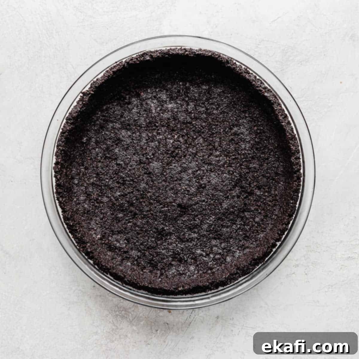 Irresistible Oreo Desserts 12 An Oreo Pie Crust in a glass pie dish on a gray background.
