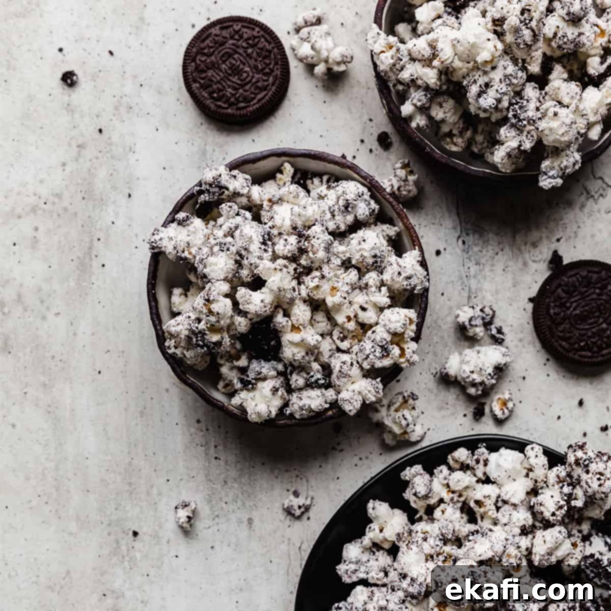 Irresistible Oreo Desserts 14 Oreo crumbs and white chocolate covered popcorn in a black bowl on a gray textured background.