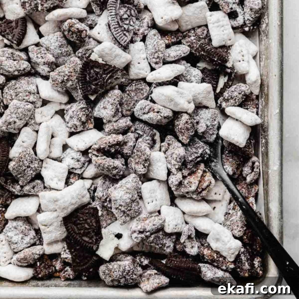 Irresistible Oreo Desserts 15 Oreo Muddy Buddies tossed with chopped Oreos on a baking sheet.