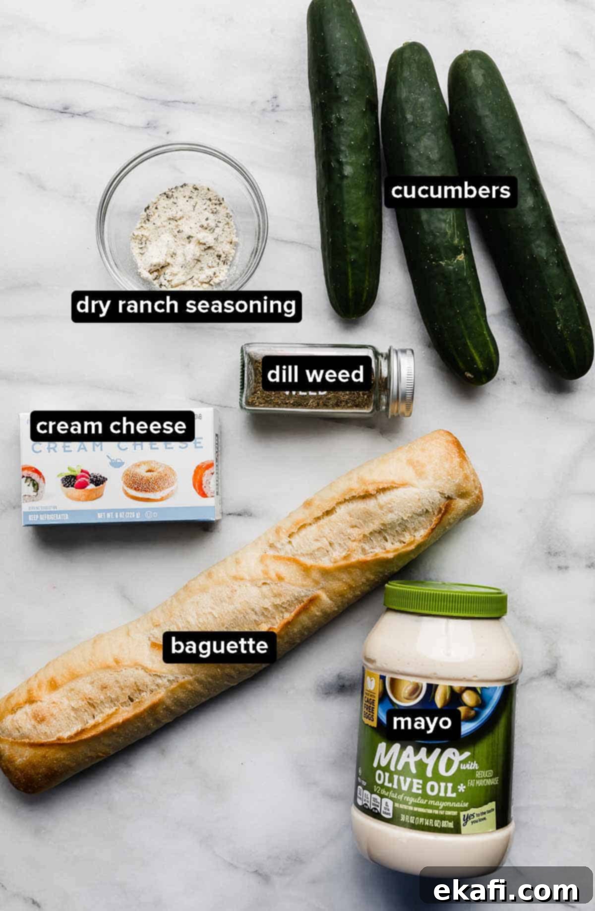 Cool Cucumber Cream Cheese Poppers 3 Cucumber Sandwich Appetizer ingredients on a white background: dill, cream cheese, cucumbers, baguette, and mayo.