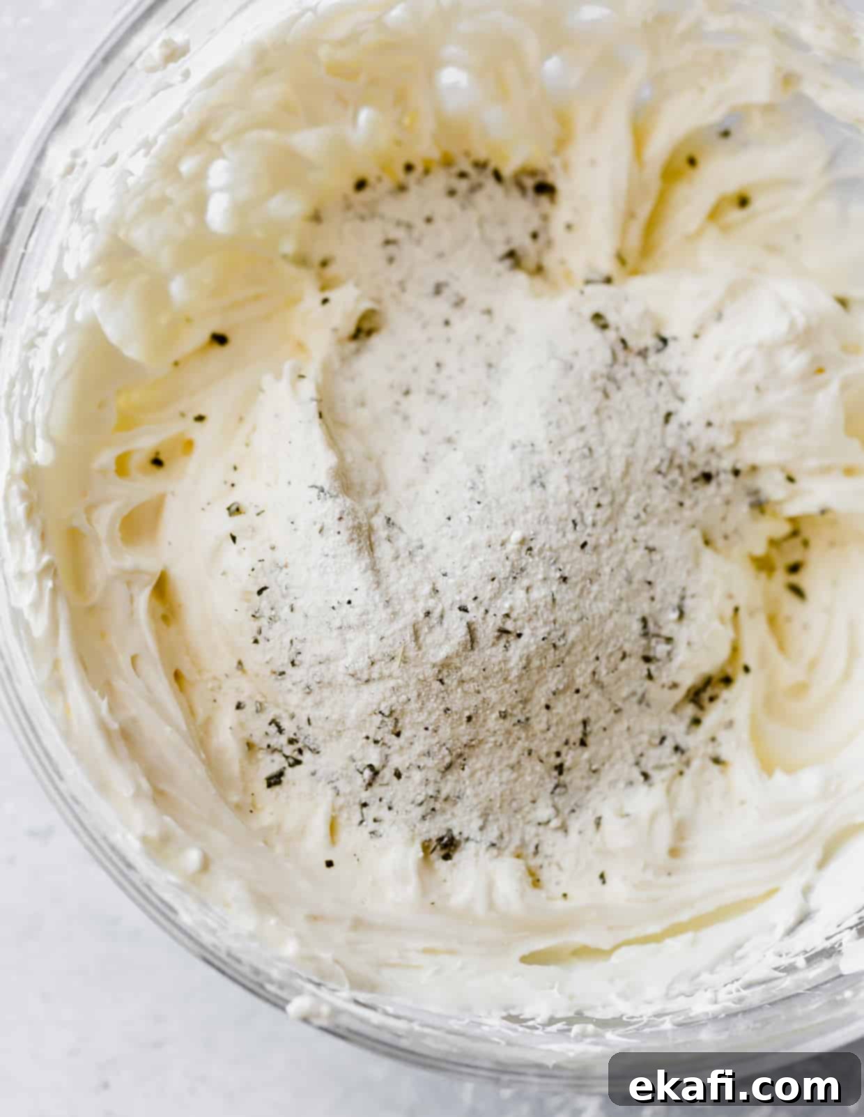 Cool Cucumber Cream Cheese Poppers 5 Dried ranch seasoning mix atop a cream cheese and mayonnaise mixture in a bowl.