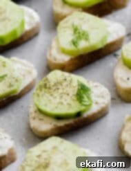 Cool Cucumber Cream Cheese Poppers 9 Cucumber Sandwich Appetizer featuring baguette slices topped with cucumber and dill.