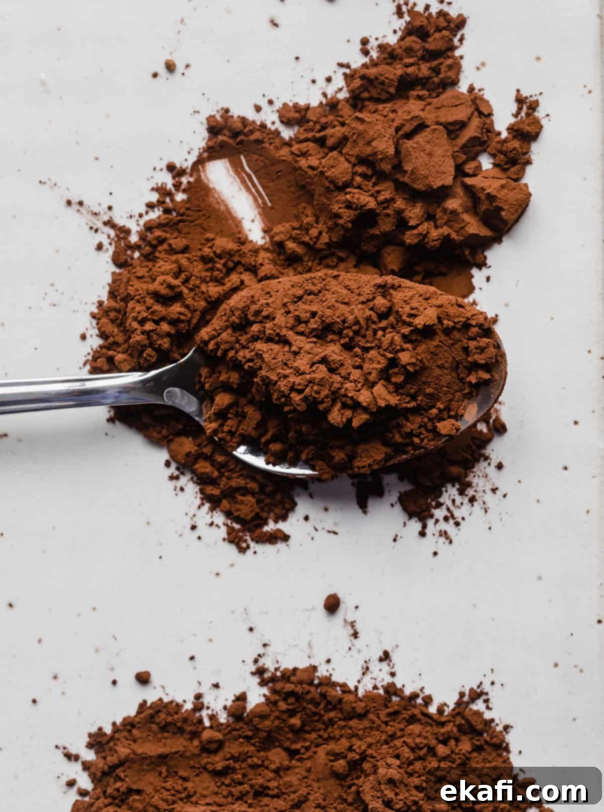 The Ultimate Guide to Baking Cocoa 4 A spoonful of dark brown Dutch processed cocoa powder, showing its deeper hue compared to natural cocoa.