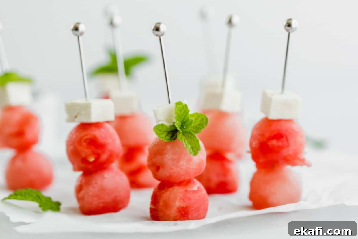 Cool Watermelon Sticks 6 Two watermelon balls and small block of feta cheese on small metal skewers, perfectly assembled and ready for balsamic glaze.