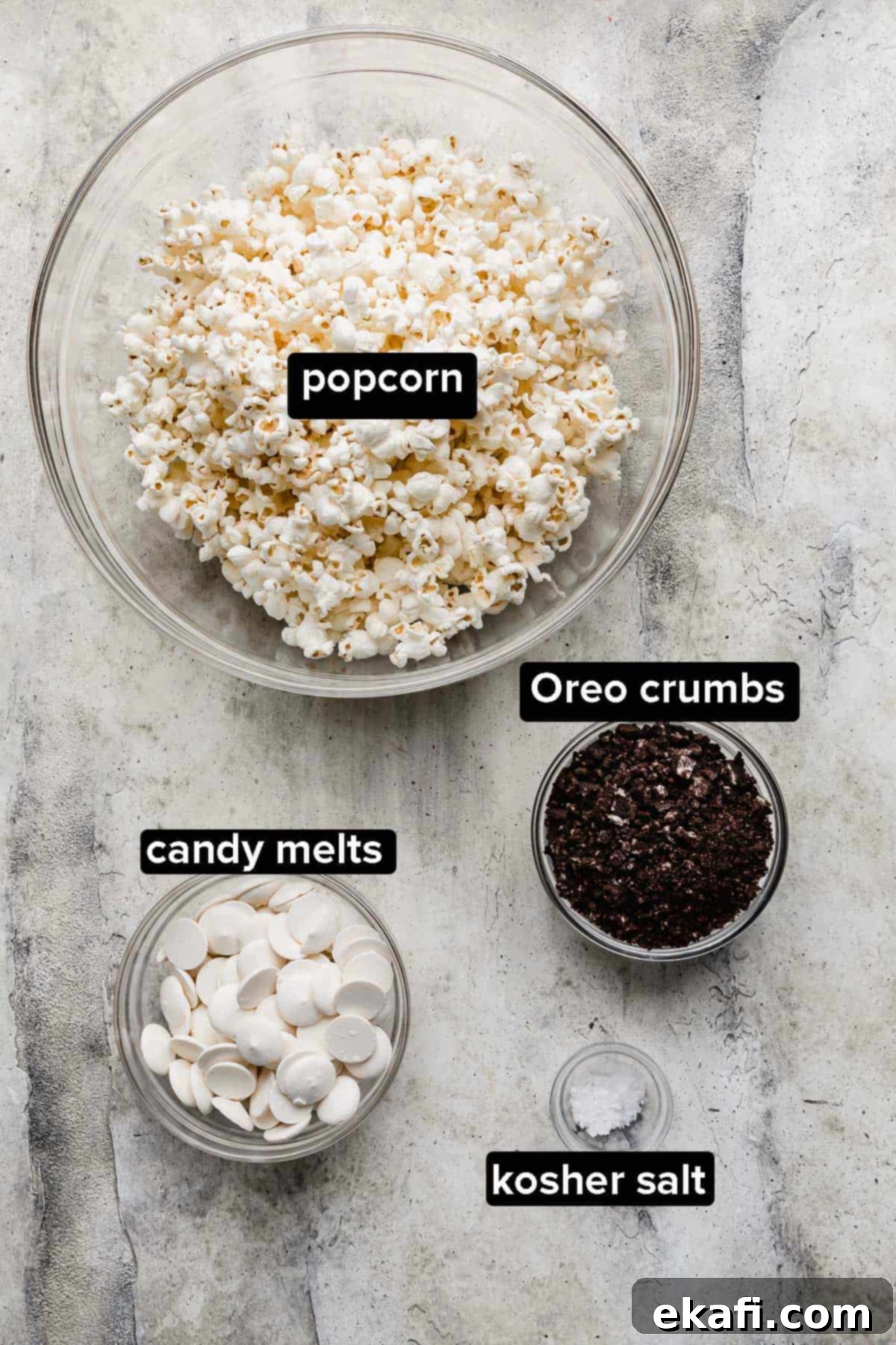 Όρεο Ποπκόρν 3 Υλικά για Ποπ Κορν Oreo σε γκρι φόντο: ποπ κορν, κουβερτούρα λευκής σοκολάτας, τριμμένα Oreo και αλάτι kosher.