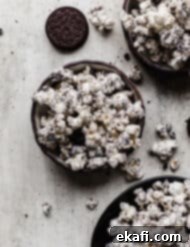 Όρεο Ποπκόρν 10 Τριμμένα μπισκότα Oreo και ποπ κορν καλυμμένο με λευκή σοκολάτα σε μαύρο μπολ σε γκρι υφή φόντου.