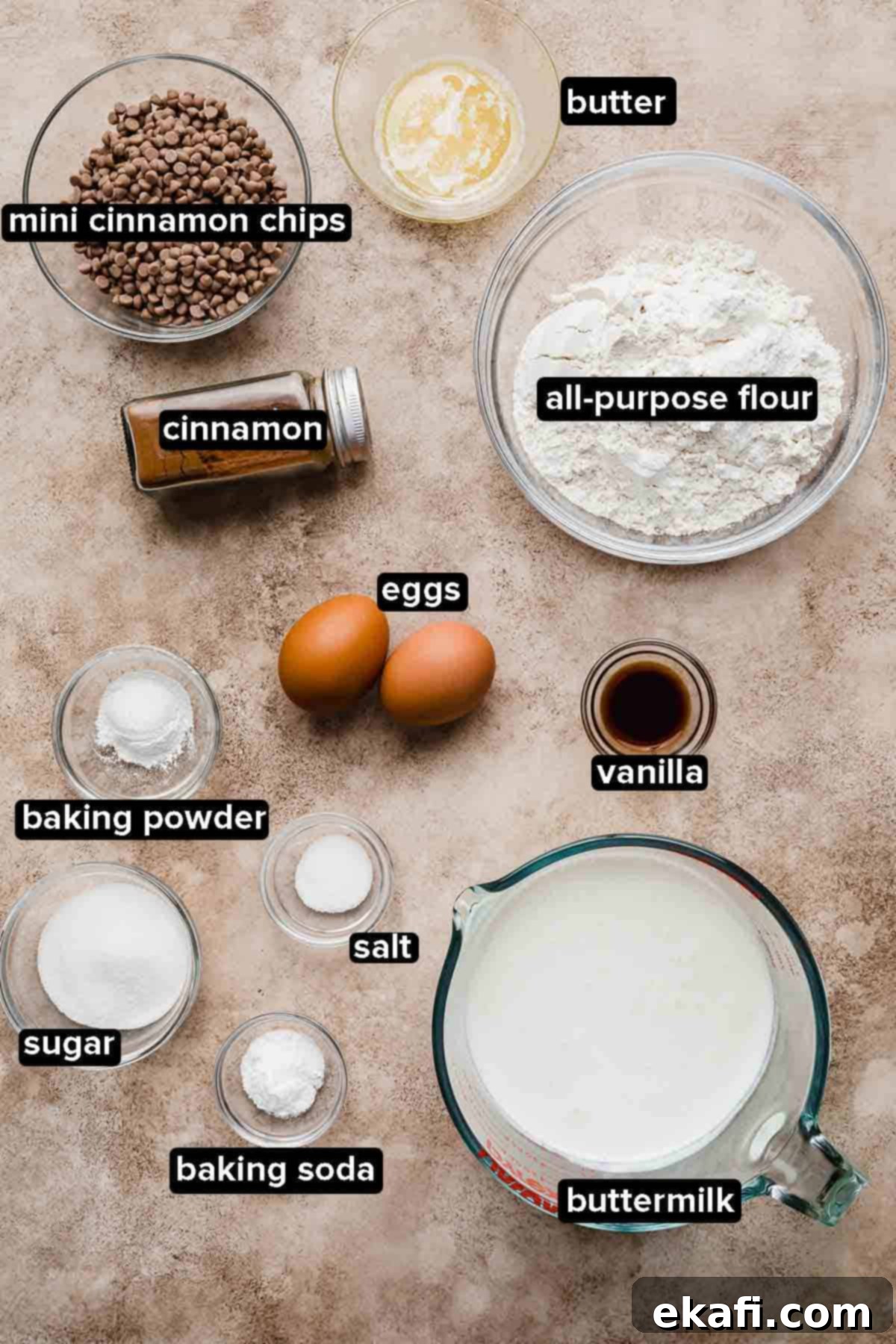 Irresistible Cinnamon Chip Pancakes 3 Cinnamon Chip Pancake ingredients portioned into glass bowls on a light brown and beige background.