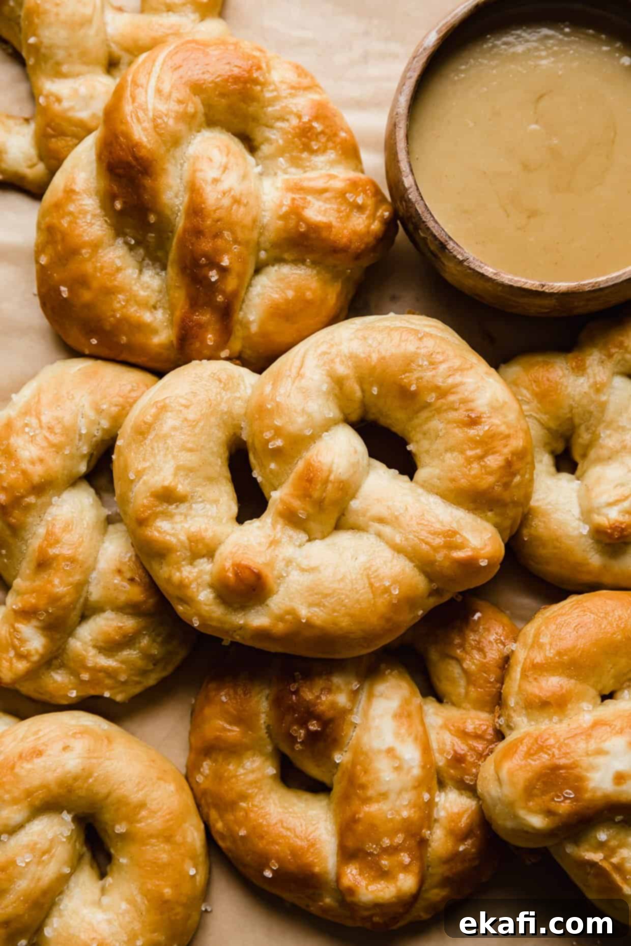 Perfect Homemade Soft Pretzels 2 Homemade Soft Pretzels freshly baked on tan parchment paper, ready to be enjoyed.