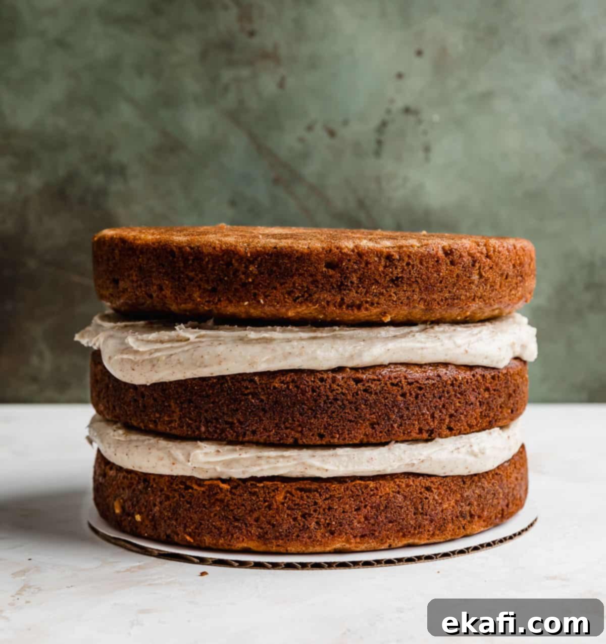 Tropical Pecan Carrot Cake 6 Three golden-brown carrot cake layers with visible pineapple and pecan inclusions, perfectly stacked with creamy toasted pecan buttercream spread generously between each layer.