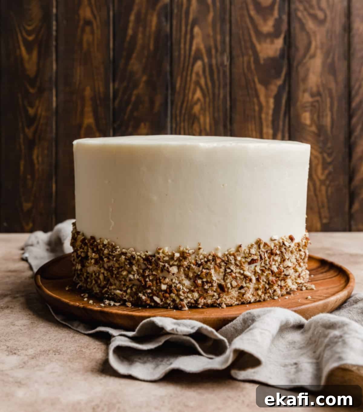 Tropical Pecan Carrot Cake 8 A perfectly layered carrot cake, beautifully frosted with smooth cream cheese frosting. The bottom third of the cake is adorned with finely chopped pecans, adding a textural and visual flourish.