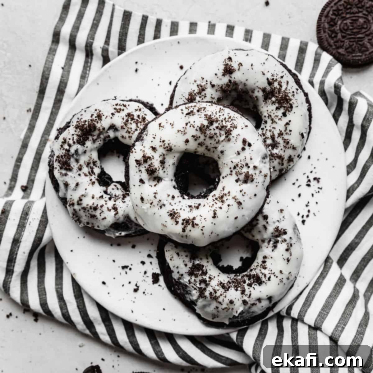 Deep & Dark Black Cocoa Delights 3 Oreo Donuts on a striped napkin.