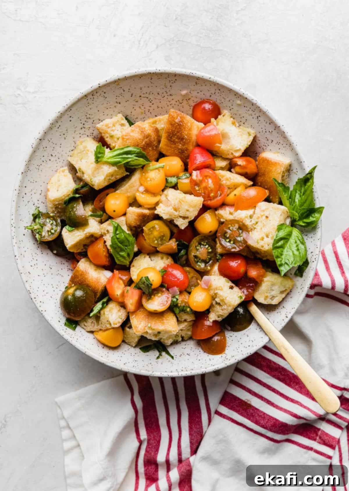 Rustic Tuscan Panzanella 2 A large white bowl with fresh Panzanella Toscana in it and garnished with basil.