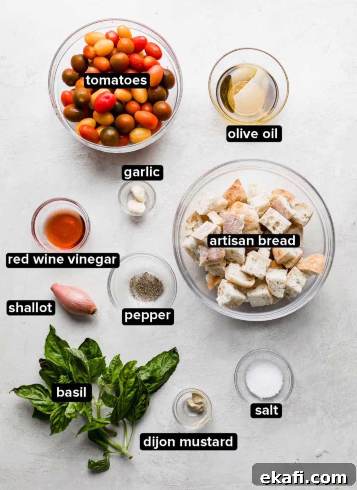 Rustic Tuscan Panzanella 3 Panzanella Toscana ingredients in glass bowls on a white background.