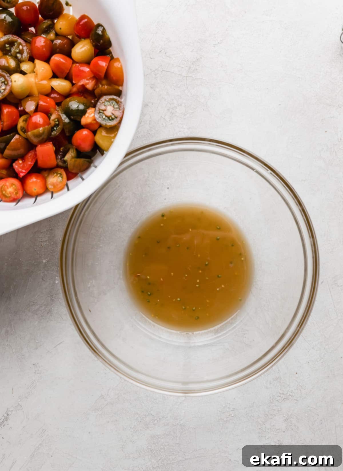 Rustic Tuscan Panzanella 5 Glass bowl with a light brown juice in it (juice from tomatoes), for making a Panzanella Toscana dressing.