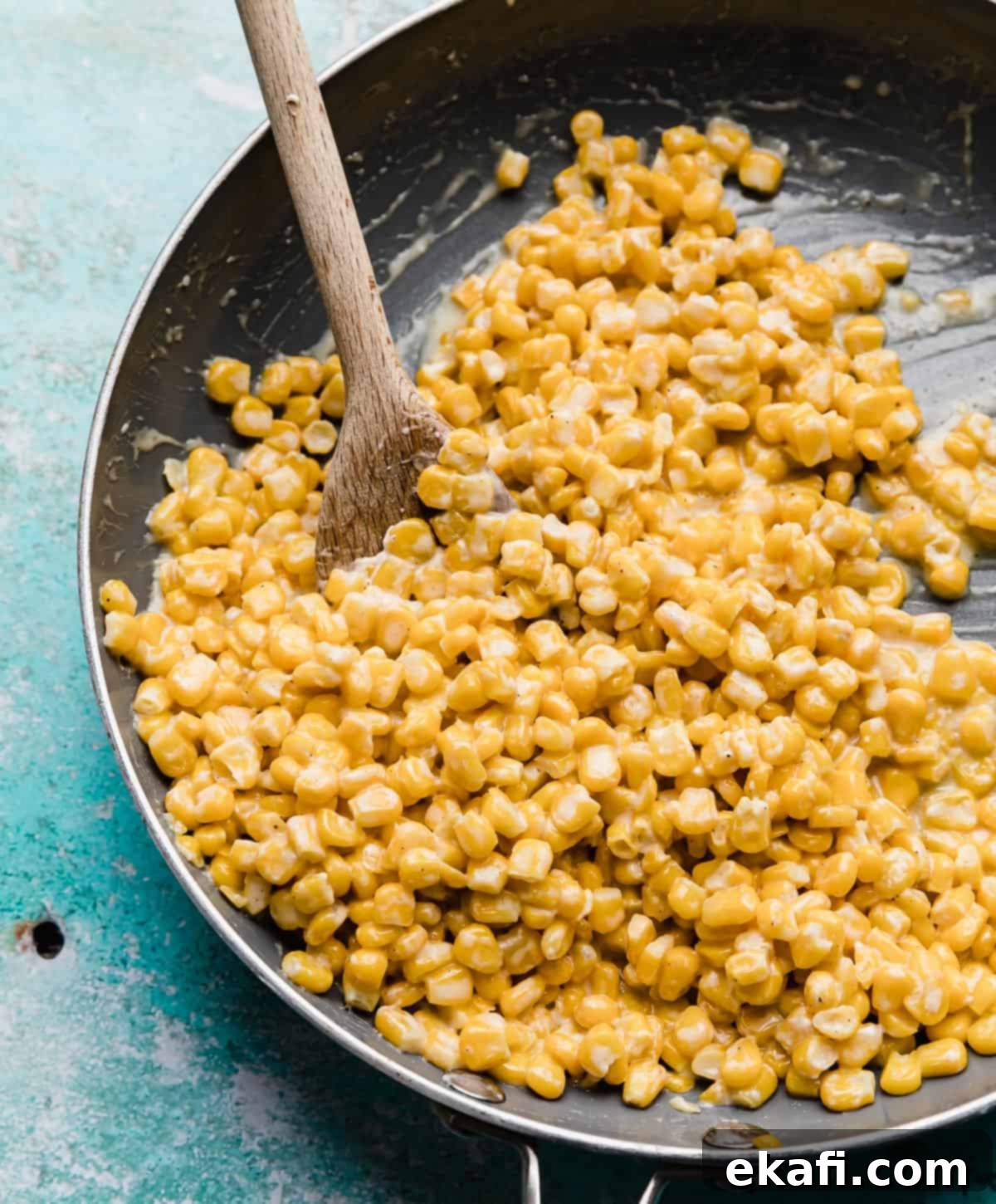 Golden Honey Butter Skillet Corn 2 Yellow Honey Butter Skillet Corn in a gray skillet on a turquoise background.