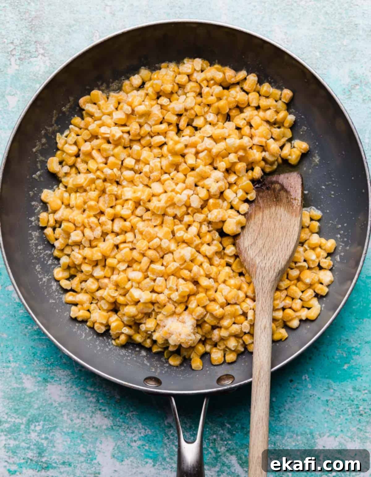 Golden Honey Butter Skillet Corn 5 A grey skillet with frozen corn kernels in it.