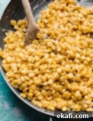Golden Honey Butter Skillet Corn 9 Yellow Skillet corn in a skillet on a turquoise background.