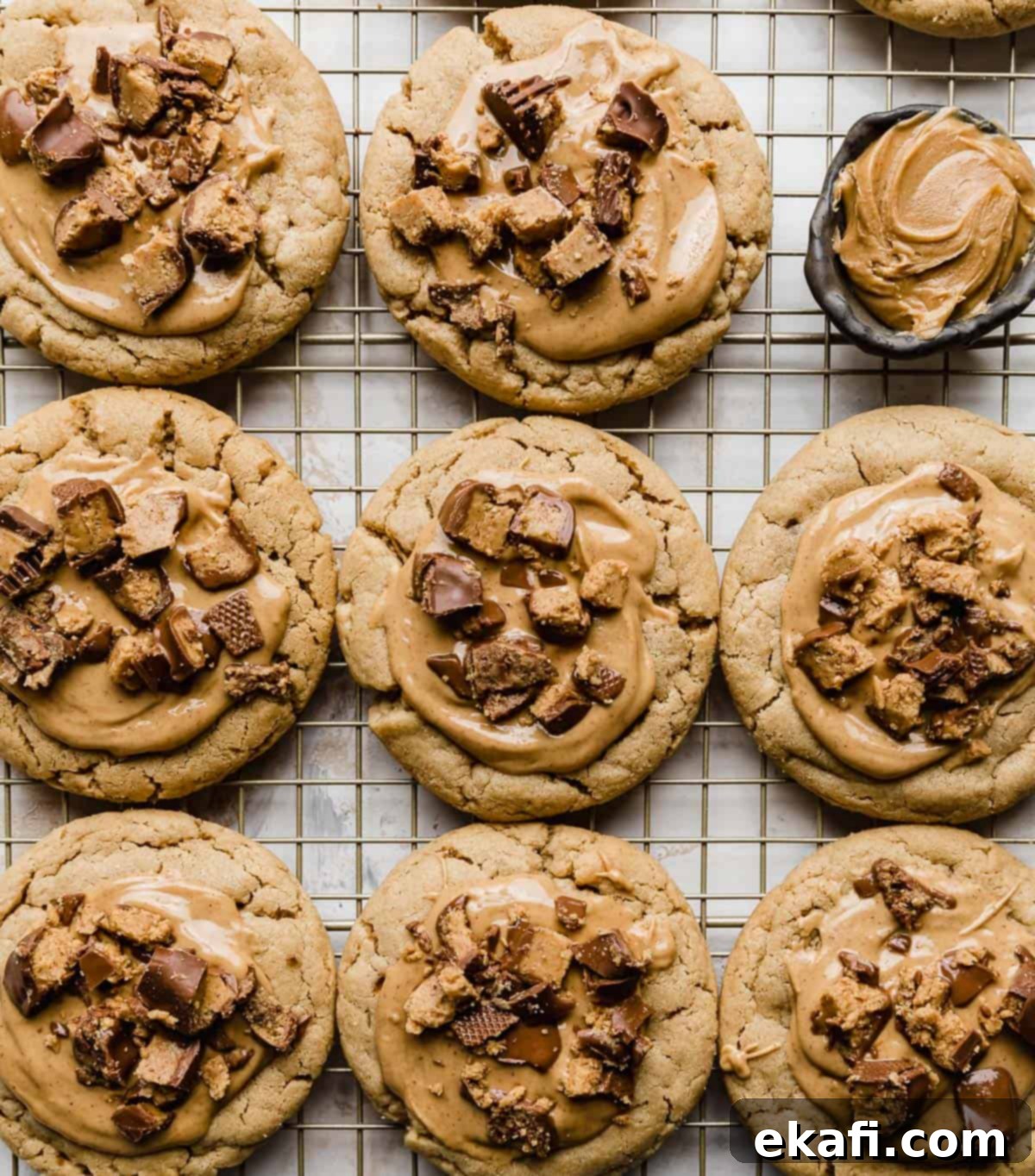 Decadent Peanut Butter Cup Cookies 8 Crumbl Peanut Butter Cup Cookies lined up on a wire rack against a white background.