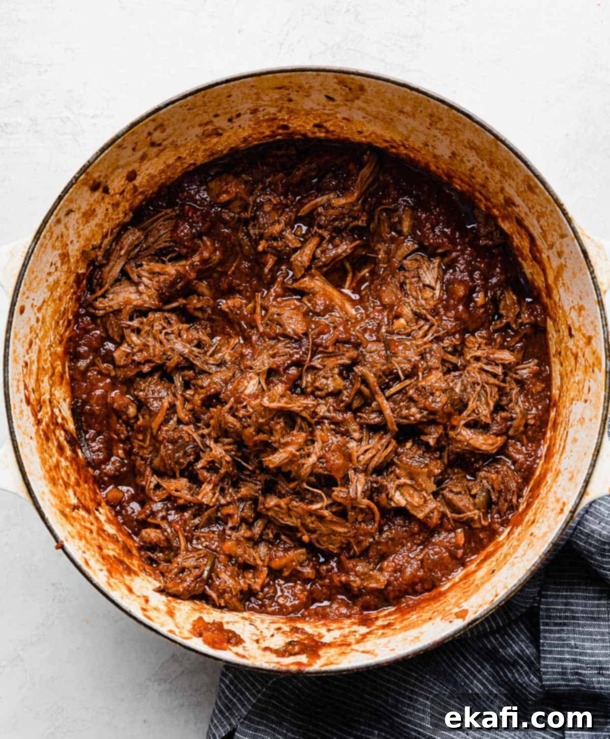 Hearty Shredded Beef Ragu 11 A shredded beef Ragu sauce in a white pot on a white background.